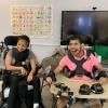 2 iHOPE students in classroom, both using wheelchairs and smiling for the photo