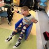 MSA student has arms in the air as they look excited while sitting on a blue plastic chair