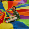 MSA student sits in the middle of a colorful parachute with colorful balls around them
