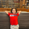 MSA student leans back against a short wall, with their hands up behind their head