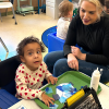 MSA student putting together colorful blocks while a staff watches on
