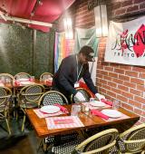 An MSA intern sets the table at Joann restaurant