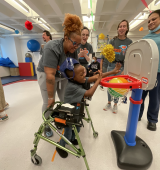 Amari plays adaptive basketball with staff and others cheering them along