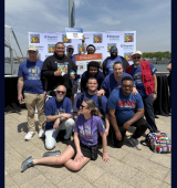 Group of people at the Best Buddies walk post on the pier with Ismael on the right hand side of the picture