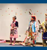 4 people in native America clothing dancing