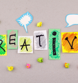 The work "creative" is spelled out on various style fonts on different papers with colorful additions around the word