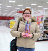 Ashley stands in a store holding "autistic Barbie"