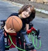Jackson holds a basketball while using the Trexo gait trainer