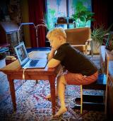 child sitting at a desk looking at a laptop