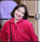 woman in red top smiles with head tilted