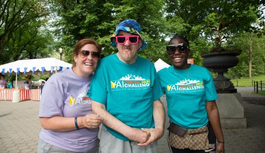 3 people stand side-by-side in Central Park NYC, one in the middle has sassy pink sunglasses on
