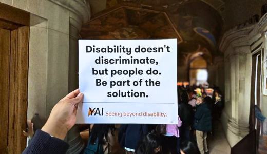 Someone holds up a rally sign at a rally in Albany "Disability doesn't discriminate, but people do. Be part of the solution."