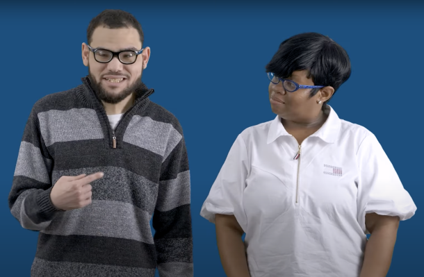 Still of "working at YAI" video, two people stand in front of a blue background