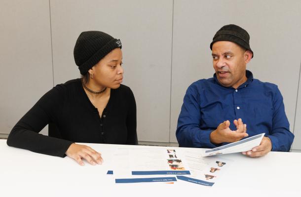 Woman and man sit side by side reviewing Easy Read papers.