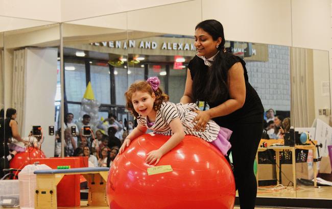 Esty is on a huge red ball, whie Krupa supports them