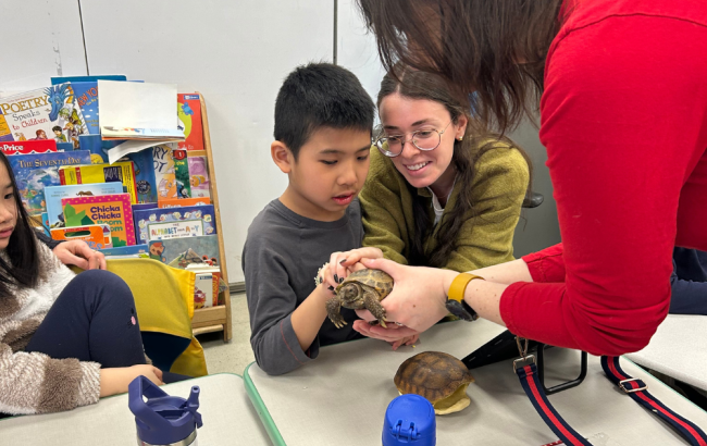 MSA student touching a tortoise that a staff person is holding for them