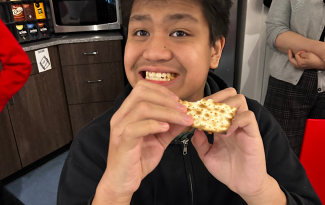MSA student smiles while holding some food they look like they're about to eat