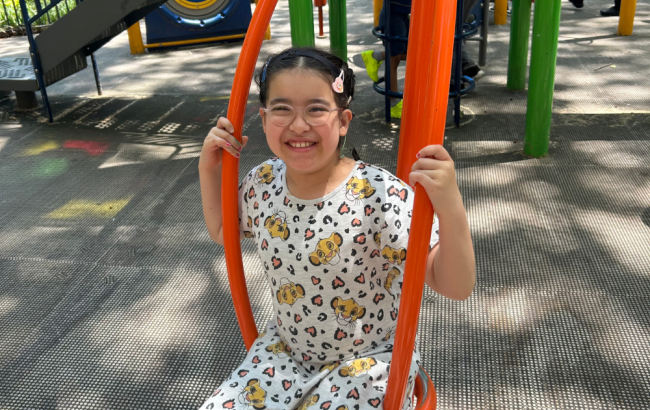 MSA student sits on a swing in a playground