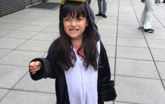 MSA student wearing a penguin onsie stands outside and smiles for photo