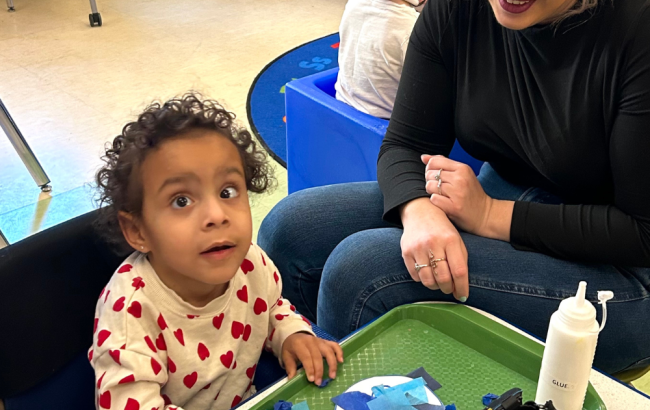 MSA student putting together colorful blocks while a staff watches on