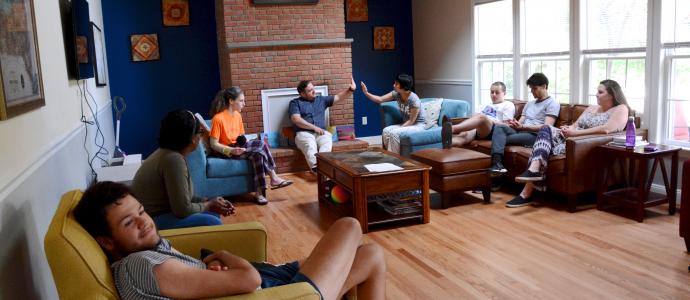 Group of people sitting in a living room of a YAI group home