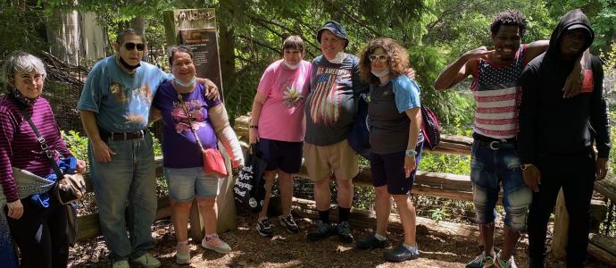 Group of people from NIPD/NJ stand in a wooded area for photo