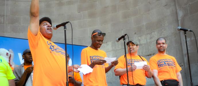 Robert stands on stage with self advocates at a past CPC event