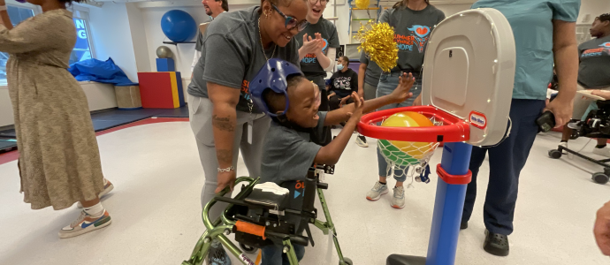 Amari plays adaptive basketball with staff and others cheering them along