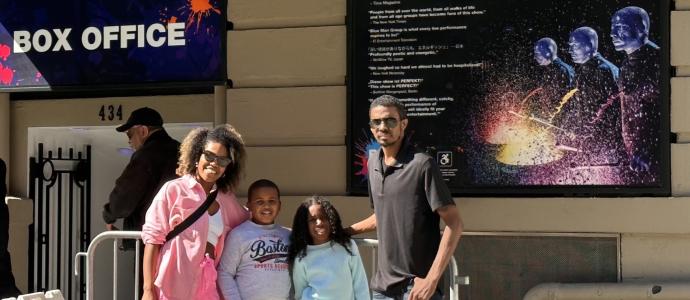 Victor and his family stand outside and pose for photo at Blue Man Group in Astor Place