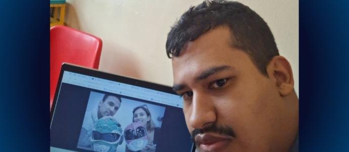 Orlando poses with computer, on it is an image of 2 power rangers