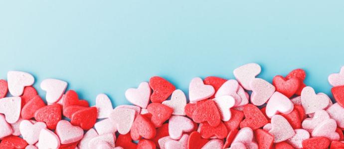Red, pink, and white candy hears on a light blue background