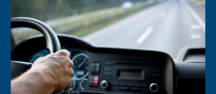 view from inside a car on the passenger side of a person driving a car on a long stretch of road