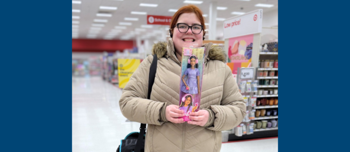 Ashley stands in a store holding "autistic Barbie"