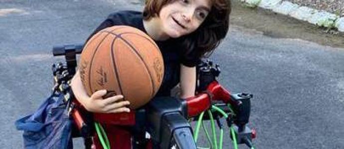 Jackson holds a basketball while using the Trexo gait trainer