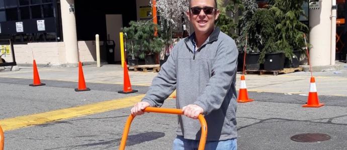 Jordan stands outside hardware store with a flatbed cart