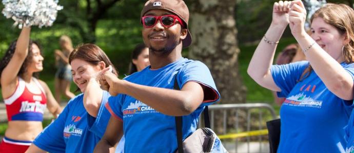 People wearing blue shirts, smiling and walking at central park challenge last year