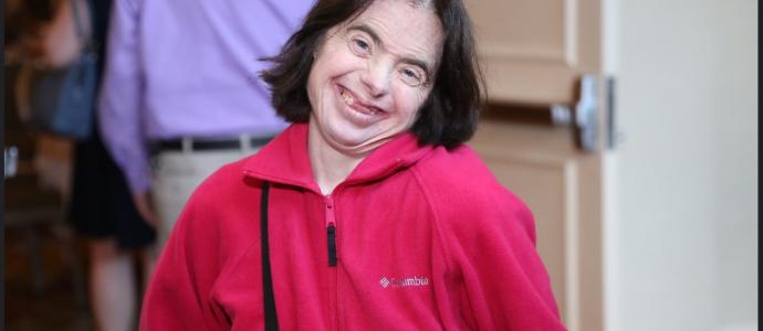 woman in red top smiles with head tilted