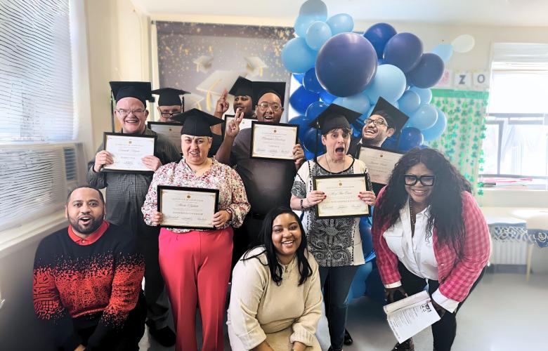Group of people celebrating graduation from therapy, they are wearing mortars and holding certificates