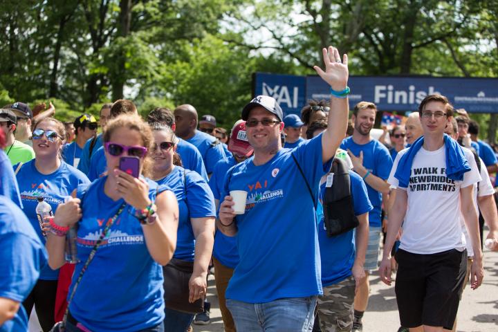 A group of people walking at the Central Park Challenge with one person waving