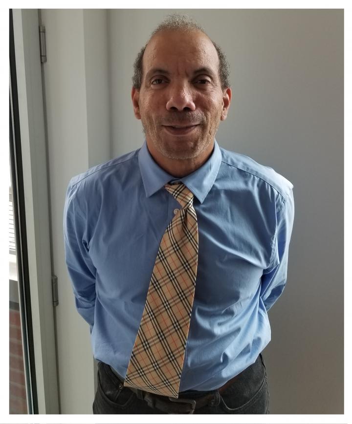 Photograph of Howard smiling and wearing a shirt and tie