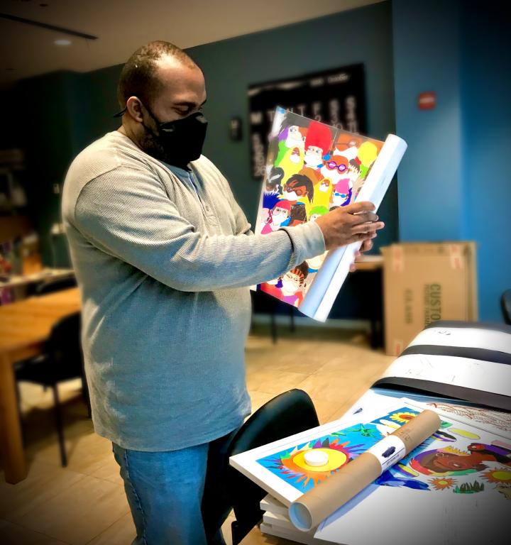 Jimmy Tucker, YAI artist, preps one of his pieces for delivery at the YAI Arts studio while practicing social distancing