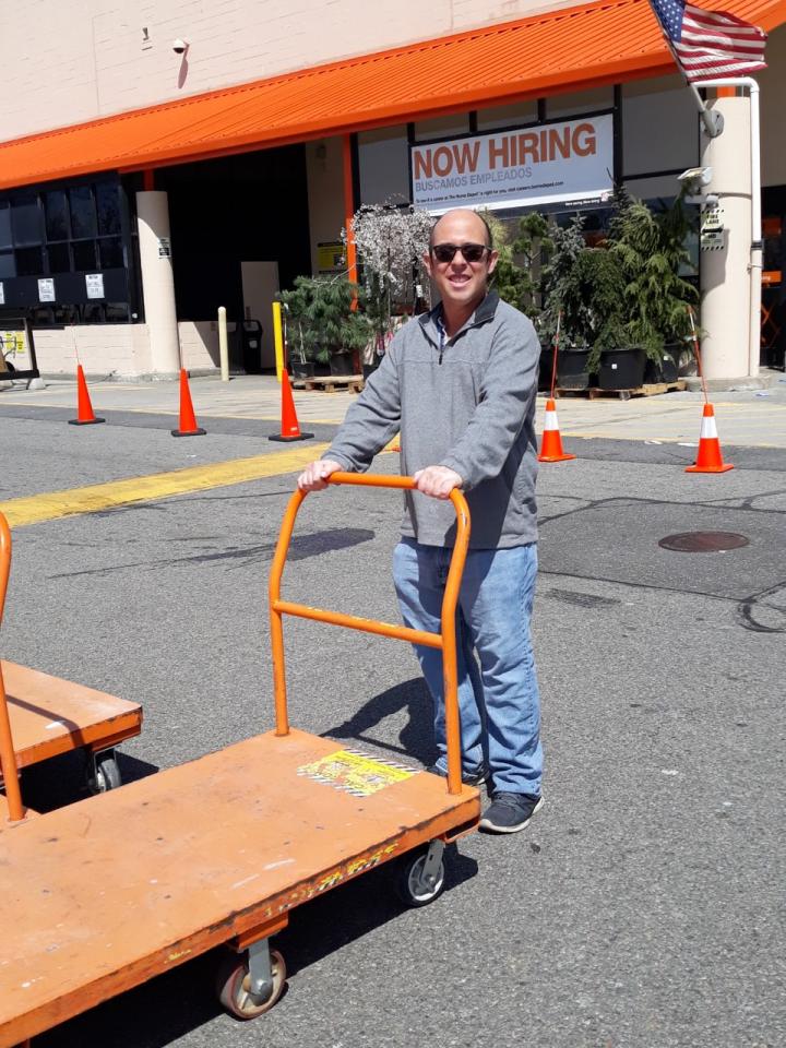 Jordan stands outside hardware store with a flatbed cart