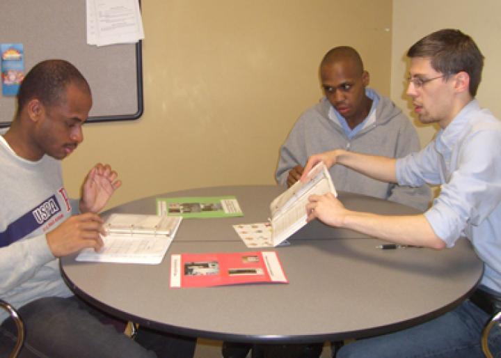 staff works with two adults with disabilities on social skills