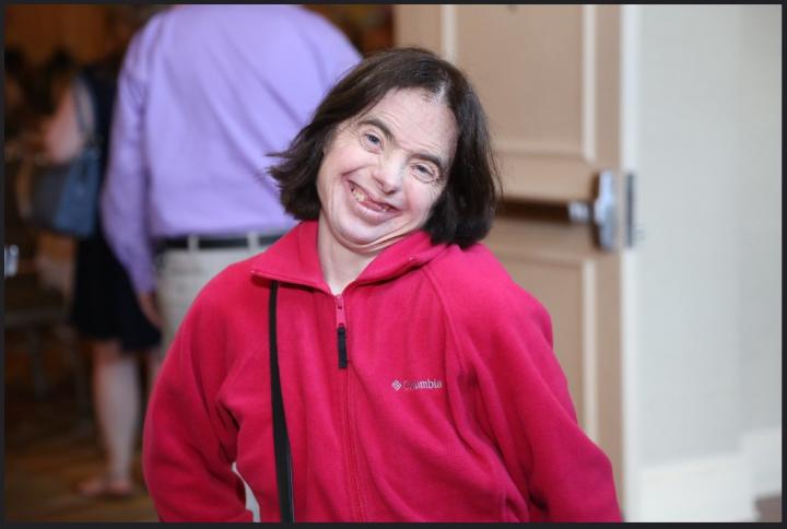 woman in red top smiles with head tilted