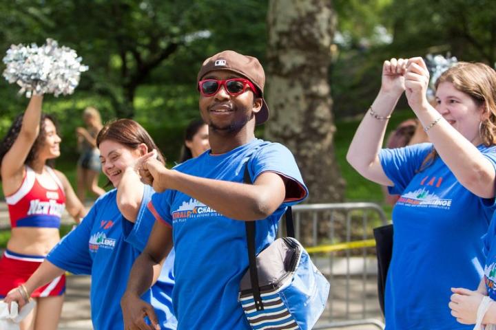 People wearing blue shirts, smiling and walking at central park challenge last year