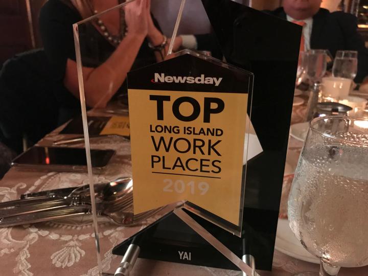 Award trophy with text "Newsday TOP Long Island Work Places 2019"