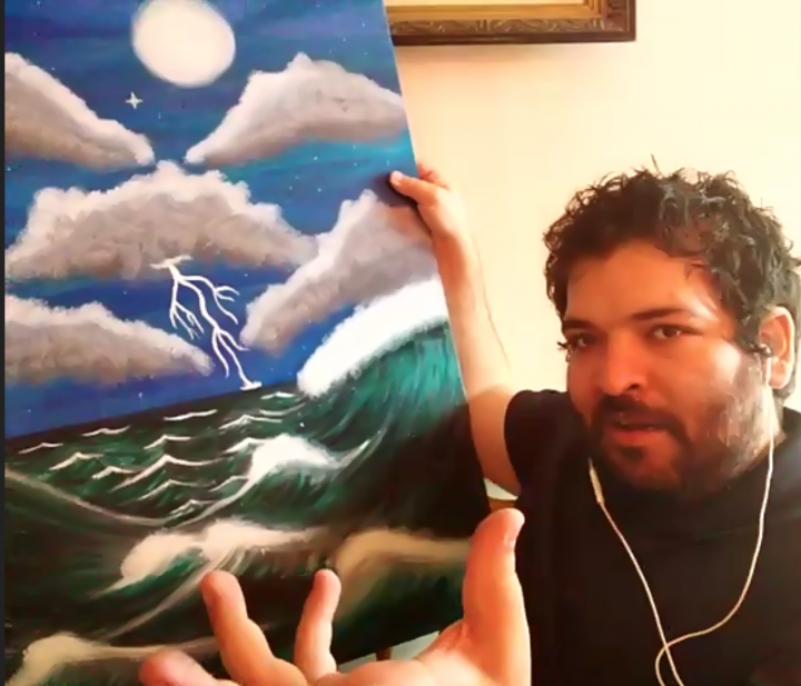 Chris Chronopoulos, YAI artist, holds his painting "The Perfect Stormy Night"