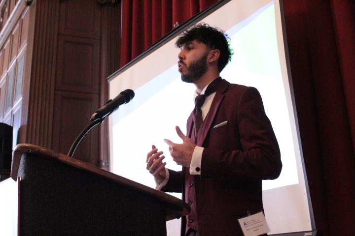 Man stands at podium talking