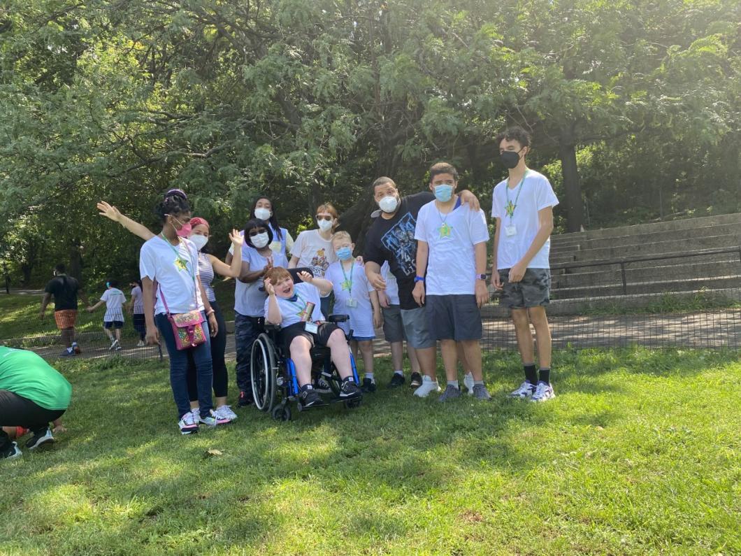 Group of children and adults from Manhattan Star Academy are out on grass pose as a group for photo