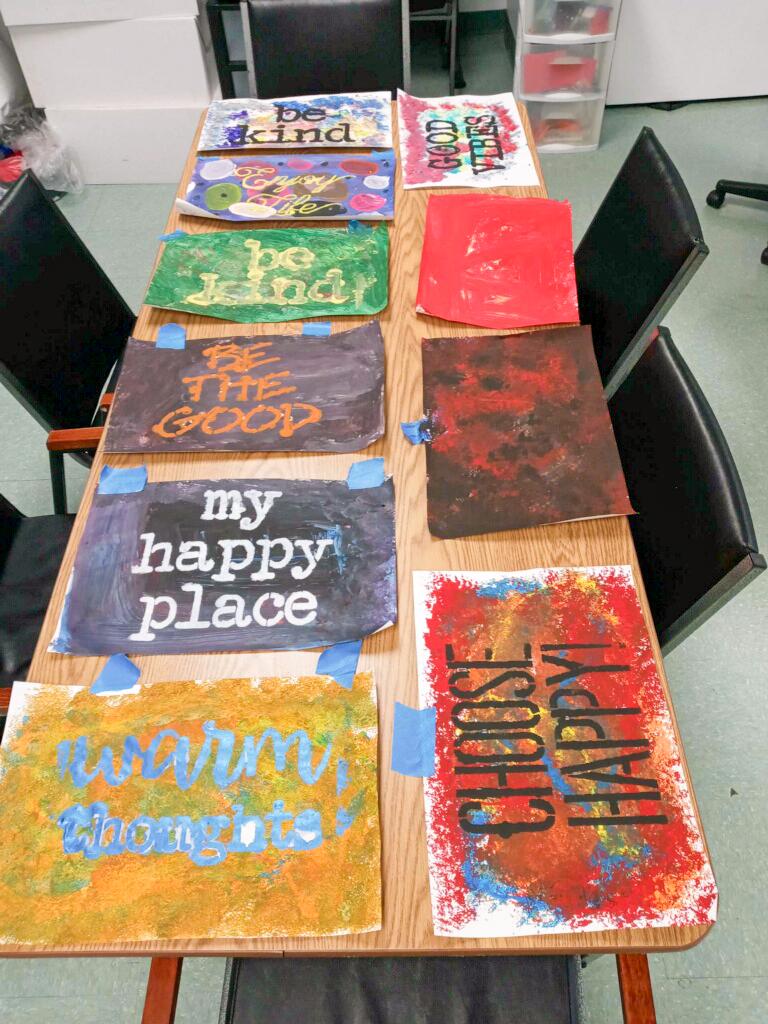 Different art pieces are laid out on a table in the Tarrytown program
